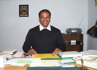 Foto von Kaplan Soni Abraham an seinem Schreibtisch sitzend